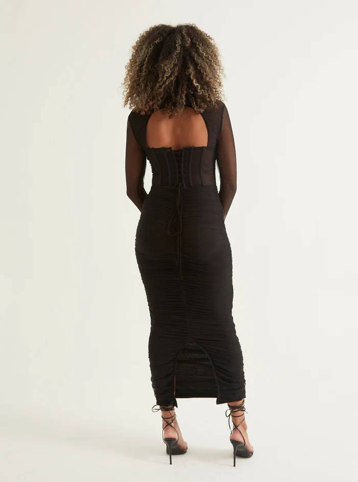 Woman wearing a black midi dress with sheer sleeves