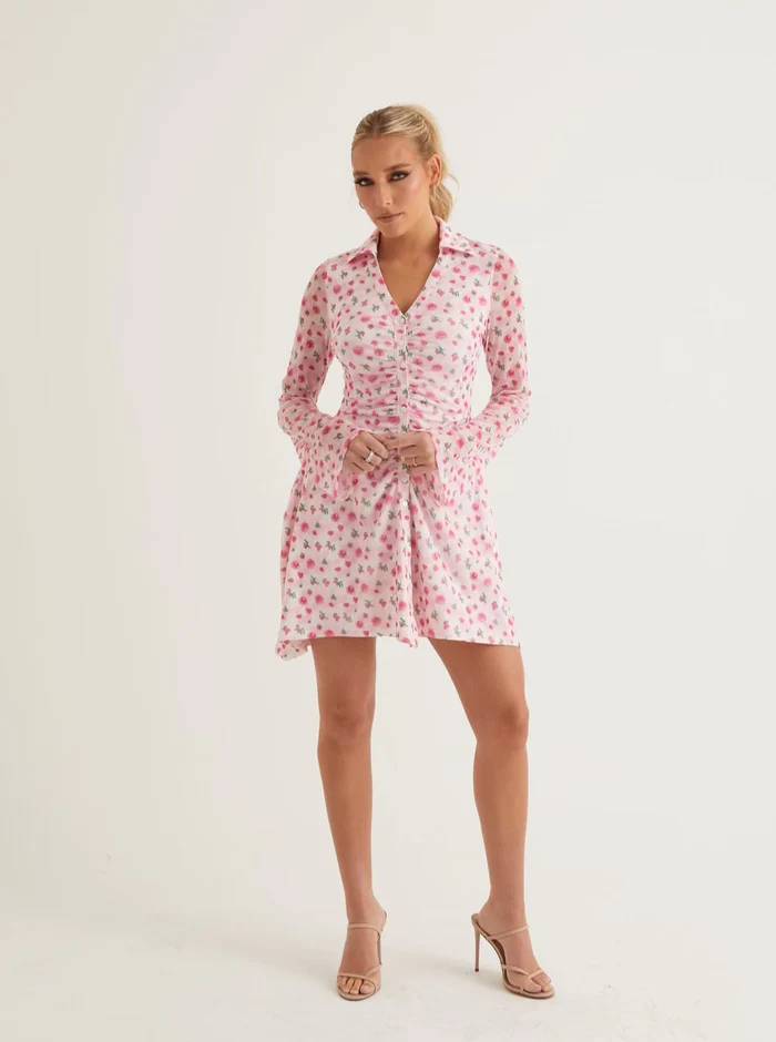 A woman wearing a floral mini dress with bell sleeves
