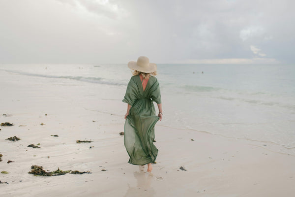 A woman in a green maxi dress at the beach