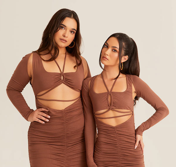 Two women in brown dresses posing